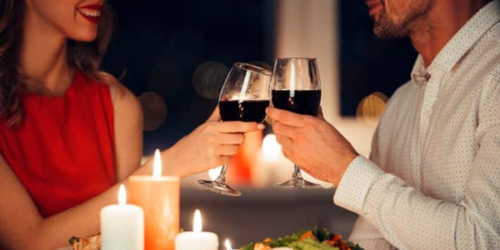 Casal com expressão de felicidade em jantar romântico em Campos do Jordão. 